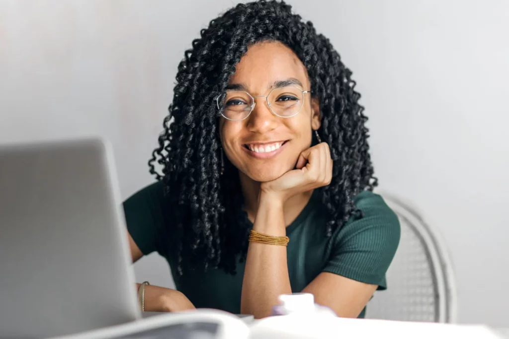 femme souriante devant un ordinateur portable