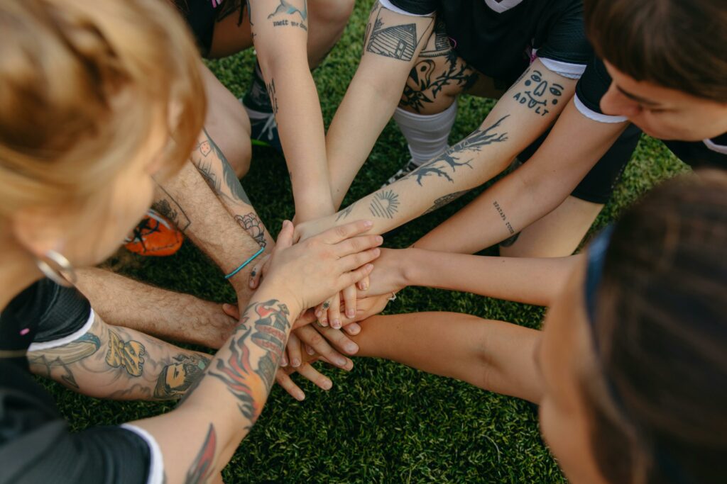 une équipe sportive féminine ont les mains rassemblées pour faire leur cri de guerre